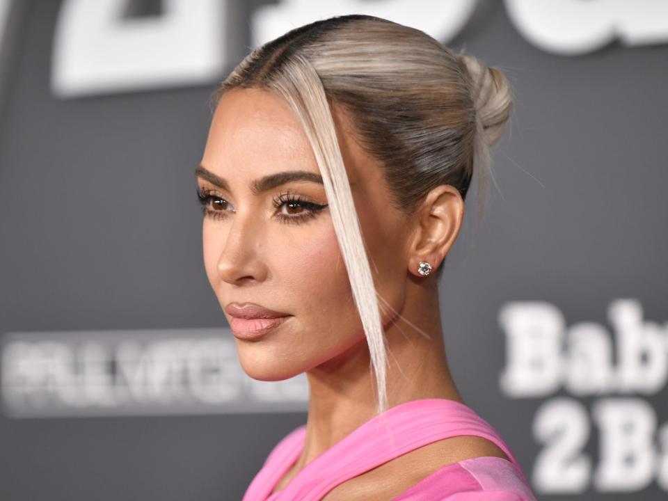 Kim Kardashian wears her platinum blonde hair in a bun while wearing a pink gown to the Baby2Baby gala in November 2022.