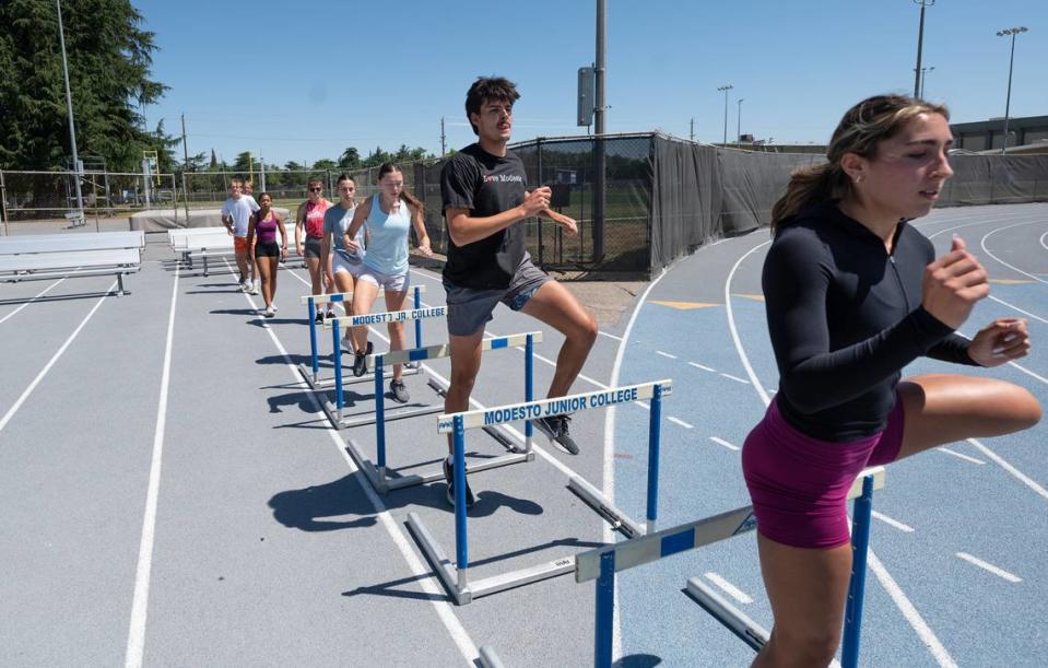 Kyndell Johnston, right, and Keith Orona, middle, warm up with their teammates during a workout at Modesto Junior College in Modesto, Calif., Tuesday, May 14, 2024.