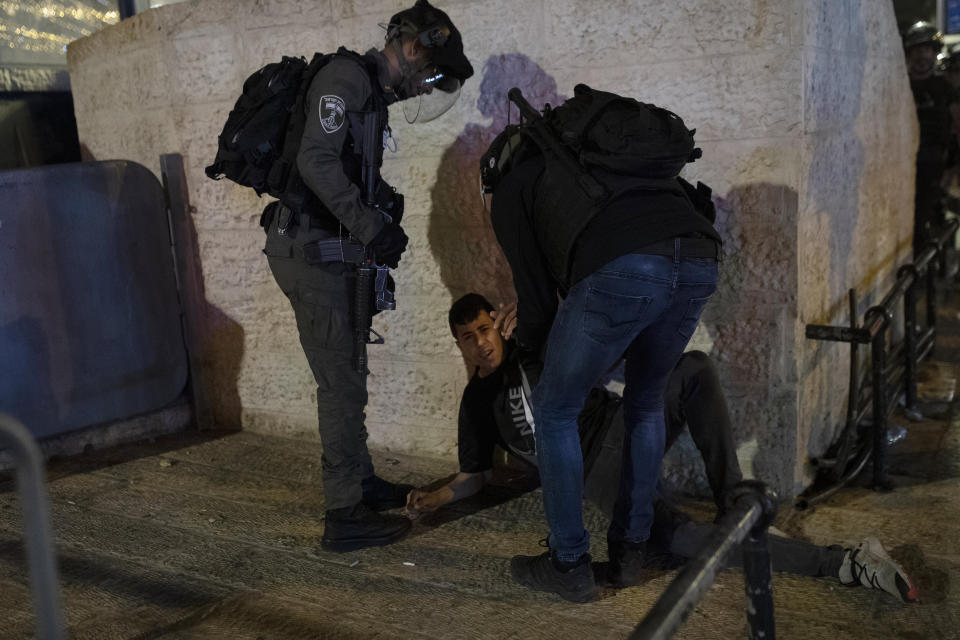 Israeli police detain a Palestinian youth at the Damascus Gate to the Old City of Jerusalem after clashes at the Al-Aqsa Mosque compound, Friday, May 7, 2021. Palestinian worshippers clashed with Israeli police late Friday at the holy site sacred to Muslims and Jews, in an escalation of weeks of violence in Jerusalem that has reverberated across the region. (AP Photo/Maya Alleruzzo)