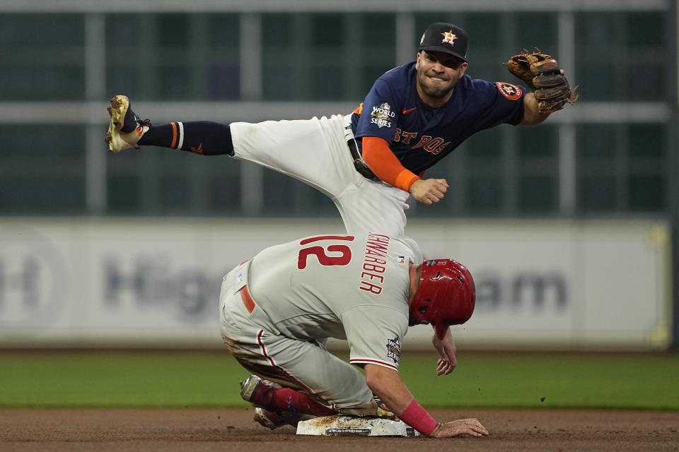 Philadelphia Phillies' Kyle Schwarber is forced out at second by Houston Astros second baseman Jose Altuve after Rhys Hoskins hit into a double play during the first inning in Game 6 of baseball's World Series between the Houston Astros and the Philadelphia Phillies on Saturday, Nov. 5, 2022, in Houston. (AP Photo/David J. Phillip)