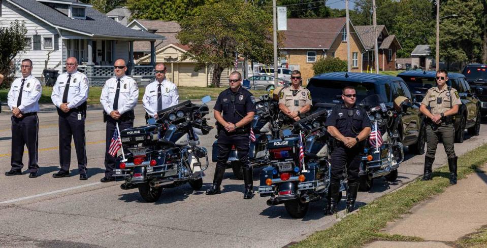 Belleville Police Chief Matt Eiskant, third from left, and other officers stand at attention on West Main Street, near the entrance of Mt. Carmel Catholic Cemetery, where fallen U.S. Marine Capt. Eleanor “Ellie” Cooke, formerly LeBeau, was buried on Saturday.