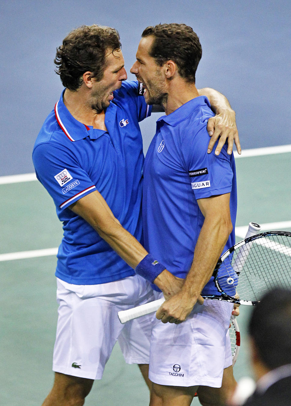 French tennis players Michael Llodra, right, and Julien Benneteau, left, celebrate winning their doubles match with against German pair Andre Begemann and Tobias Kamke, in the quarterfinals of the Davis Cup between France and Germany, in Nancy, eastern France, Saturday, April 5, 2014. Germany still leads with a 2-1 score.(AP Photo/Remy de la Mauviniere)