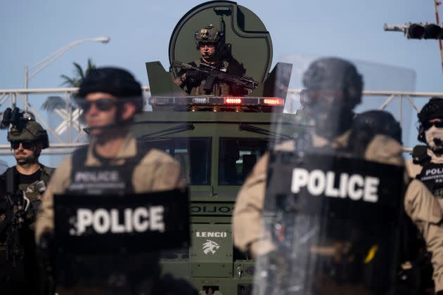 A police officer in military gear watches protesters from an armored vehicle during a May 31, 2020, rally in Miami in response to the police murder of George Floyd in Minneapolis a week earlier. (Photo: RICARDO ARDUENGO/AFP via Getty Images)