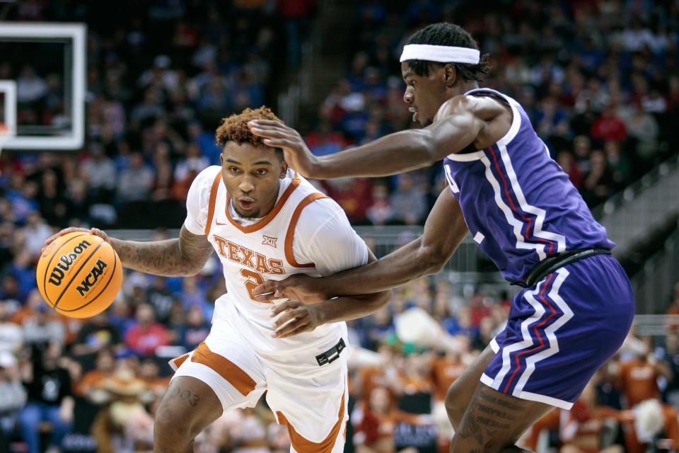 Then with Texas, Arterio Morris (2) drives the ball around TCU Horned Frogs forward Emanuel Miller (2) during the first half of a Big 12 Conference tournament game March 10 in Kansas City.