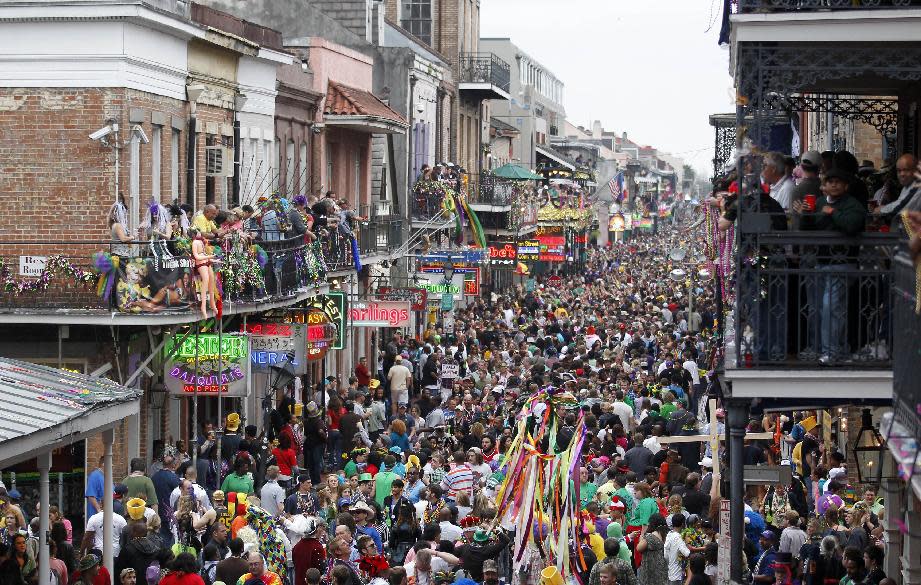 FILE - In this March 8, 2011 file photo, crowds throng Bourbon Street in the French Quarter on Mardi Gras day in New Orleans. New Orleans is perhaps best-known for hosting one of the biggest free parties in the world: Mardi Gras. The Carnival season includes parades with costumed riders, marching bands and decorated floats. (AP Photo/Gerald Herbert, file)