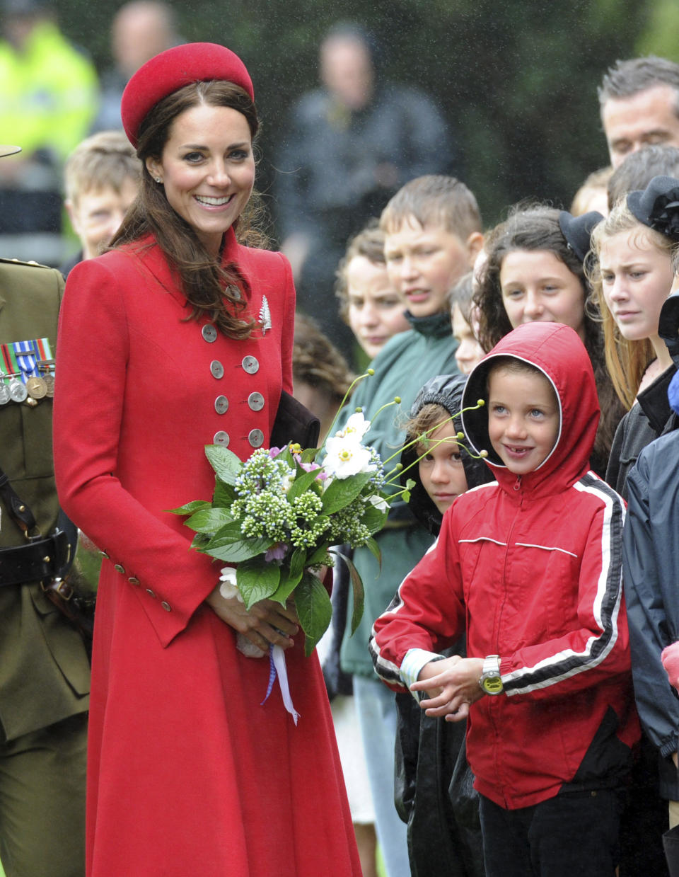 Britain's Kate, the Duchess of Cambridge smiles after receiving a bouquet of flowers from school children at the official welcome ceremony at Government House, in Wellington, New Zealand, Monday, April 7, 2014. Britain's Prince William and his wife, Kate, arrived in New Zealand's capital to cheers from locals who braved windy, rainy weather to catch a glimpse of the royal couple. (AP Photo/SNPA, Ross Setford) NEW ZEALAND OUT