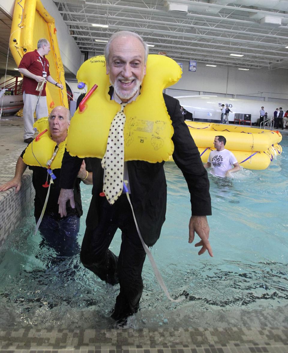 In this photo made Thursday, Jan. 26, 2012, Lou Pizzarello, front, is followed by Randy Petersen during a water aircraft landing emergency exercise at the American Airlines training facility in Fort Worth, Texas. In the ultimate field trip for aviation geeks, 160 of frequent fliers chartered an American Airlines jet and hoped across the country visiting aviation industry spots. (AP Photo/LM Otero)