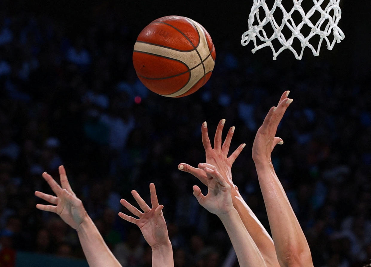 Players reach for the ball during Serbia vs. Spain basketball game in France on Saturday. 