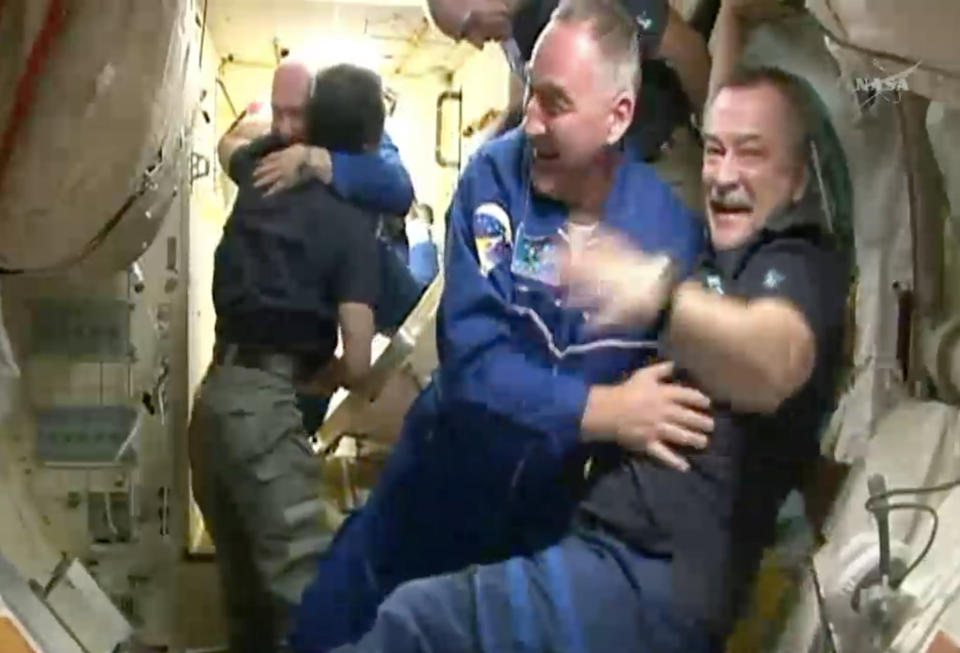 In this frame grab from video provided by NASA, Expedition 39 Soyuz Commander Aleksander Skvortsov, facing, second from right, of the Russian Federal Space Agency, is welcomed aboard the International Space Station by fellow Russian cosmonaut Mikhail Tyurin, right, Thursday, March 27, 2014, after the Soyuz docked. At left, Japanese astronaut Koichi Wakata welcomes Russian cosmonaut Oleg Artemyev, background, through the hatch of the space station. The new crew will stay in orbit for six months. (AP Photo/NASA)