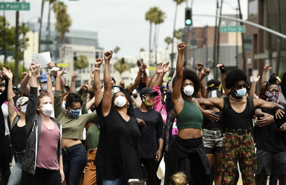 FILE - In this June 5, 2020, file photo, protesters raise their fists during a rally in support of Black Lives Matter outside the Academy of Motion Picture Arts & Sciences in Beverly Hills, Calif. Juneteenth 2020 will be a day of protest in may places Friday, June 19. Celebrations held from coast to coast will include marches and demonstrations of civil disobedience. (AP Photo/Chris Pizzello)