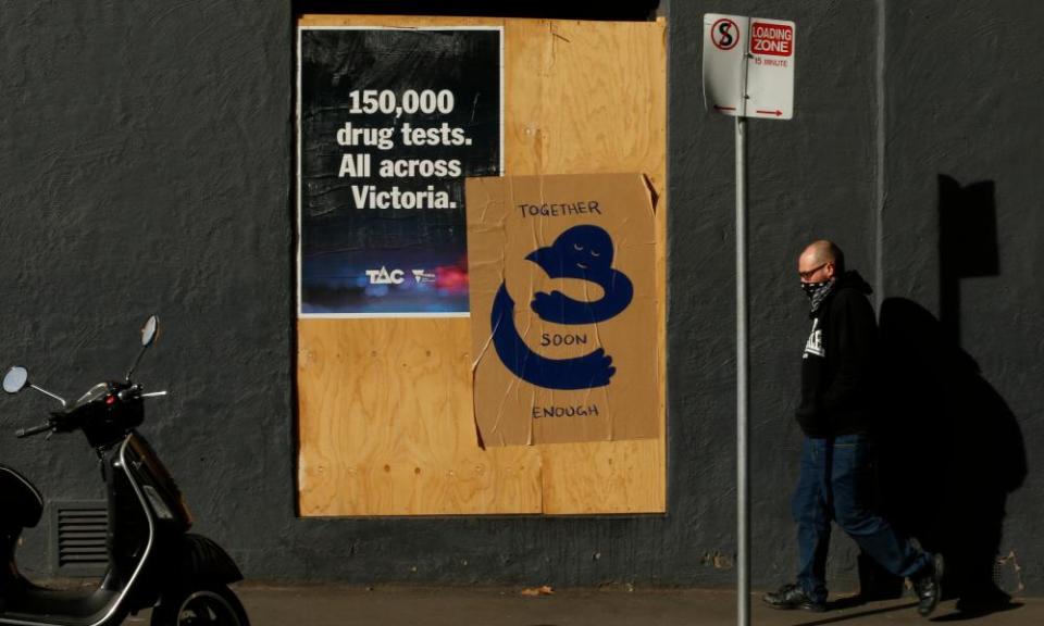 A man walks past a boarded up hotel in Melbourne, Australia