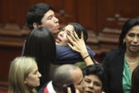 Lawmaker Rosselli Amuruz celebrates with colleagues after congresspeople verbally voted to remove President Pedro Castillo from office in Lima, Peru, Wednesday, Dec. 7, 2022. Peru's Congress voted to remove Castillo from office Wednesday and replace him with the vice president, shortly after Castillo tried to dissolve the legislature ahead of a scheduled vote to remove him.(AP Photo/Guadalupe Pardo)