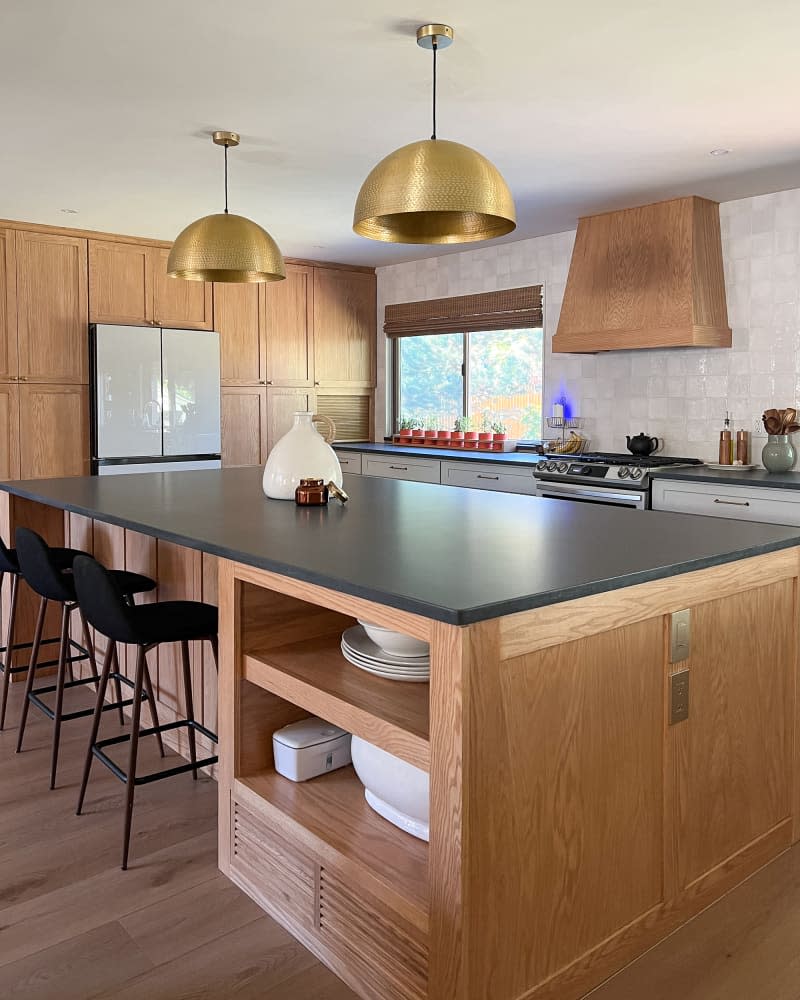 Large wooden kitchen island with black surfaces.