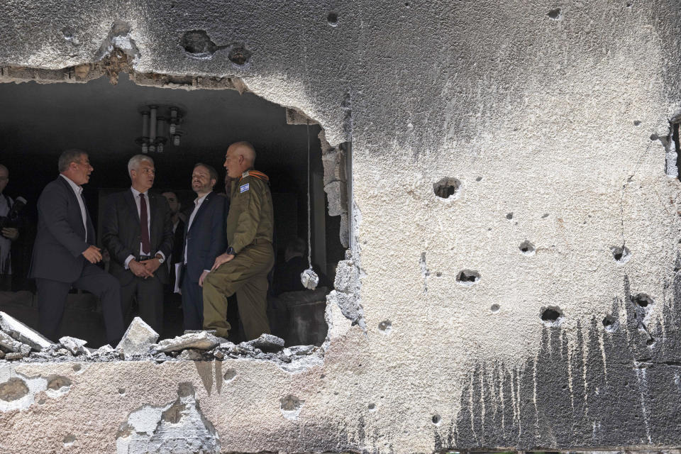 Israeli Foreign Minister Gabi Ashkenazi, left, Slovakia's Foreign Minister Ivan Korcok, second left, and Czech Foreign Minister Jakub Kulhanek, second from right, visit the site of a rocket attack in the central Israeli city of Petah Tikvah, Thursday, May 20, 2021. Heavy airstrikes pummeled a street in the Jabaliya refugee camp in northern Gaza, destroying ramshackle homes with corrugated metal roofs nearby. The military said it struck two underground launchers in the camp used to fire rockets at Tel Aviv. (AP Photo/Sebastian Scheiner)