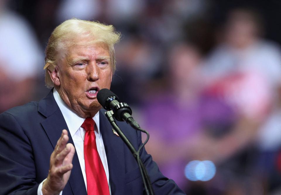 Republican presidential nominee and former U.S. President Donald Trump wears a flesh-colored bandage on his ear as he holds a campaign rally for the first time with his running mate, Republican vice presidential nominee U.S. Senator J.D. Vance (R-OH) in Grand Rapids, Michigan, U.S. July 20, 2024. REUTERS/Tom Brenner