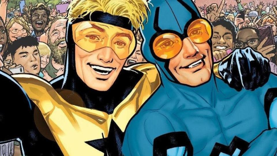 Blue Beetle and Booster Gold standing together with arms around each other