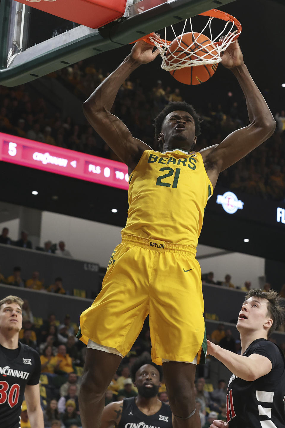 Baylor center Yves Missi (21) dunks nextx to Cincinnati guard Simas Lukosius, right, and forward Viktor Lakhin (30) during the first half of an NCAA college basketball game Saturday, Jan. 13, 2024, in Waco, Texas. (AP Photo/Jerry Larson)