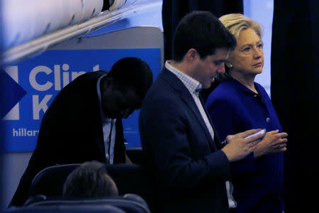 U.S. Democratic presidential nominee Hillary Clinton stands with traveling political advisor Darren Peters (L), traveling press secretary Nick Merrill (C) on her campaign plane in Ft. Lauderdale, Florida, U.S. November 2, 2016. REUTERS/Brian Snyder