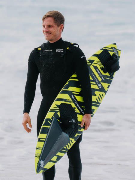 a man carrying a surfboard