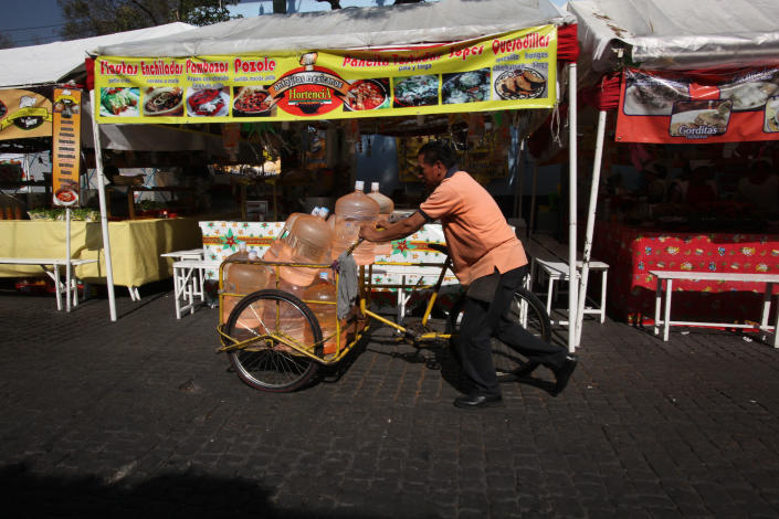 In this Jan. 4, 2014 photo, a vendor pushes his bicycle cart filled with 18-liter jugs of bottled water to sell to owners of street food stalls in Mexico City. Bad tap water accounts in part for Mexico being the highest consumer of bottled water and sweetened drinks. A law recently approved by Mexico City’s legislators will require all restaurants to install filters, offering patrons free, apparently drinkable potable water that won’t lead to stomach problems and other ailments. With an obesity epidemic looming nationwide, the city’s health department decided to back the water initiative. (AP Photo/Marco Ugarte)