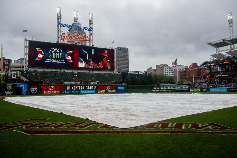 Sep 29, 2024; Cleveland, Ohio, USA; The tarp covers the field as the game between the Cleveland Guardians and the Houston Astros is delayed at Progressive Field. Mandatory Credit: Ken Blaze-Imagn Images