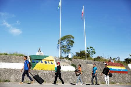 FILE PHOTO - Venezuelans walk across the border from Venezuela into the Brazilian city of Pacaraima, Roraima state, Brazil November 16, 2017. REUTERS/Nacho Doce