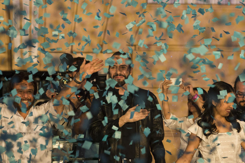 Presidential candidate Nayib Bukele, of the Grand Alliance for National Unity, center, his wife Gabriela, right, and the Vice-president candidate Felix Ulloa wave supporters in San Salvador, El Salvador, Sunday, Feb. 3, 2019. Bukele, a youthful former mayor of the capital, easily won El Salvador's presidency, getting more votes than his three rivals combined to usher out the two parties that dominated politics for a quarter century in the crime-plagued Central America nation. (AP Photo/Moises Castillo)