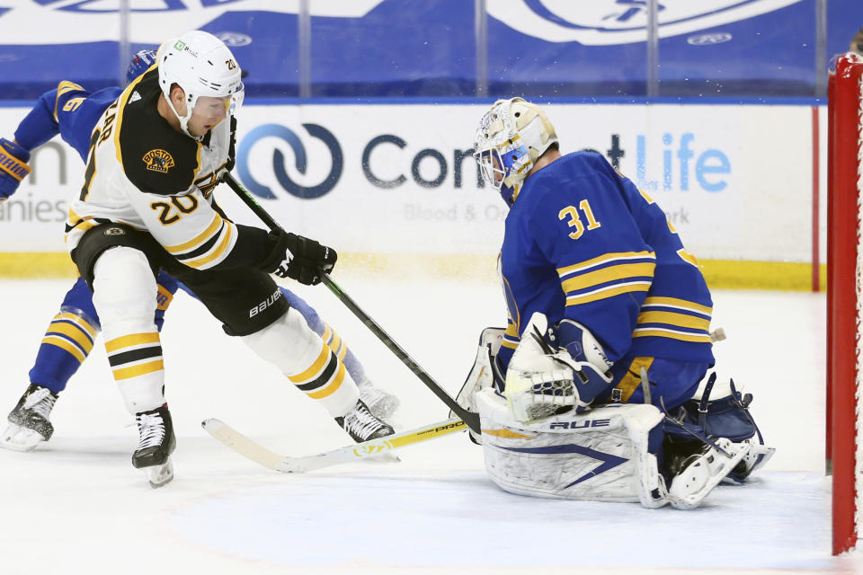 Buffalo Sabres goalie Dustin Tokarski (31) stops Boston Bruins forward Curtis Larzar (20) during the first period of an NHL hockey game, Thursday, April 22, 2021, in Buffalo, N.Y. (AP Photo/Jeffrey T. Barnes)