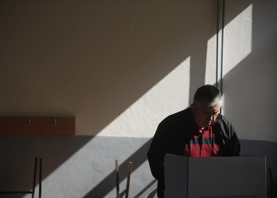 A man prepares his ballot in order to vote at a polling station during a referendum in Skopje, Macedonia, Sunday, Sept. 30, 2018. Macedonians were deciding Sunday on their country's future, voting in a crucial referendum on whether to accept a landmark deal ending a decades-old dispute with neighbouring Greece by changing their country's name to North Macedonia, to qualify for NATO membership and also pave its way toward the European Union. (AP Photo/Thanassis Stavrakis)