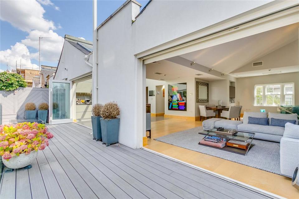 <p>The open plan living space opens up through sliding doors to a wonderful wooden terrace, and then an astro-turfed sun deck. </p>