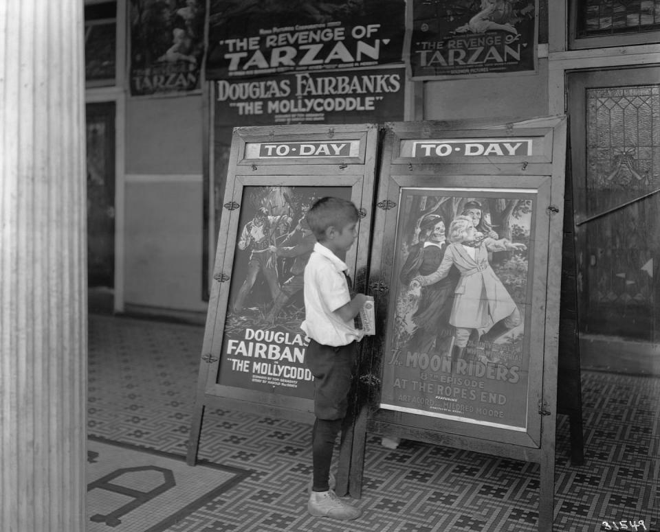 <p>A young boy looks at the movie posters outside a Minneapolis movie theater.</p>