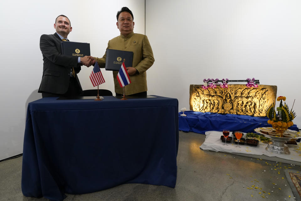 Tatum King, left, special agent in charge of Homeland Security Investigations in San Francisco, shakes hands Mungkorn Pratoomkaew, right, Consul-General of Thailand in Los Angeles, during a ceremony to return two stolen hand-carved sandstone lintels dating back to the 9th and 10th centuries to the Thai government Tuesday, May 25, 2021, in Los Angeles. The 1,500-pound (680-kilogram) antiquities had been stolen and exported from Thailand — a violation of Thai law — a half-century ago, authorities said, and donated to the city of San Francisco. They had been exhibited at the San Francisco Asian Art Museum. (AP Photo/Ashley Landis)