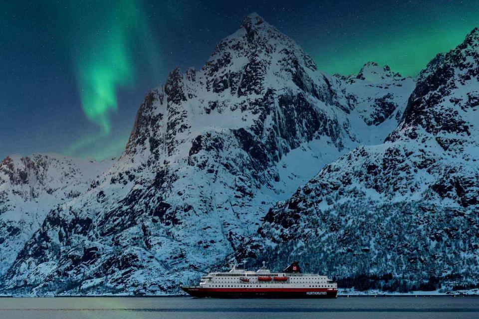 <p>Stian Klo/Courtesy of Hurtigruten</p> One of Hurtigruten’s hybrid-powered ships, the Richard With, sails beneath the northern lights in Norway.