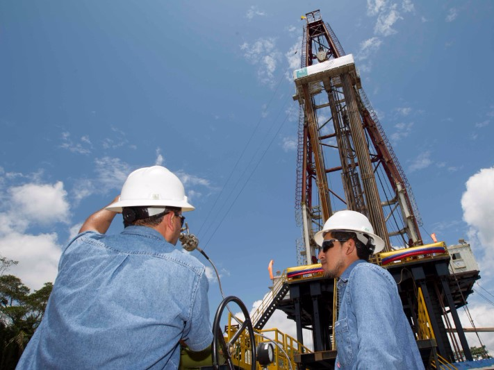 Workers stand near an oil drilling rig belonging to Petroamazonas at Miranda Port in Tiputini, Ecuador September 7, 2016. REUTERS/Guillermo Granja 