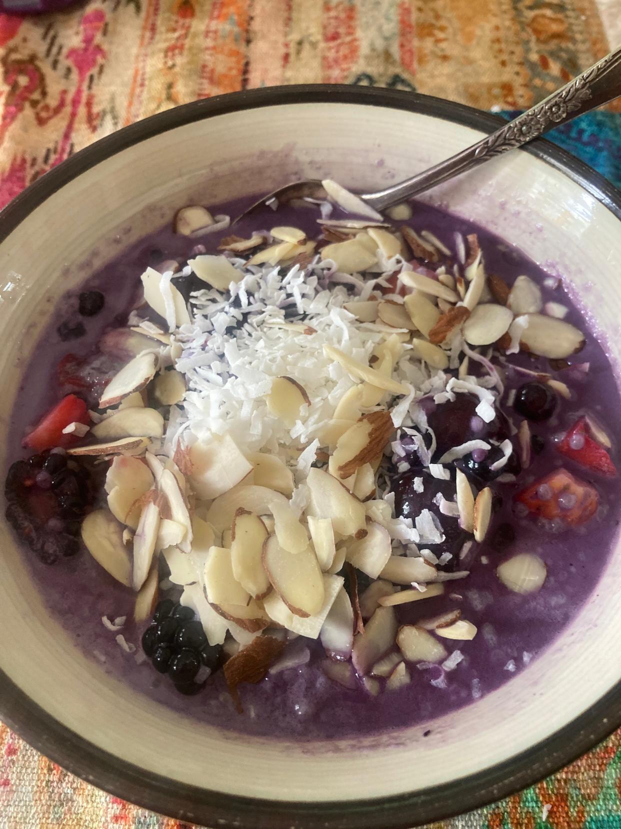 Homemade almond milk with berries, chia seeds, coconut flakes and almond slices.