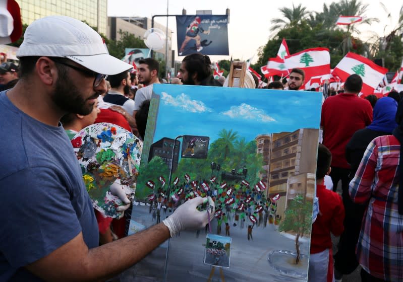 A man paints during an anti-government protest in the port city of Sidon