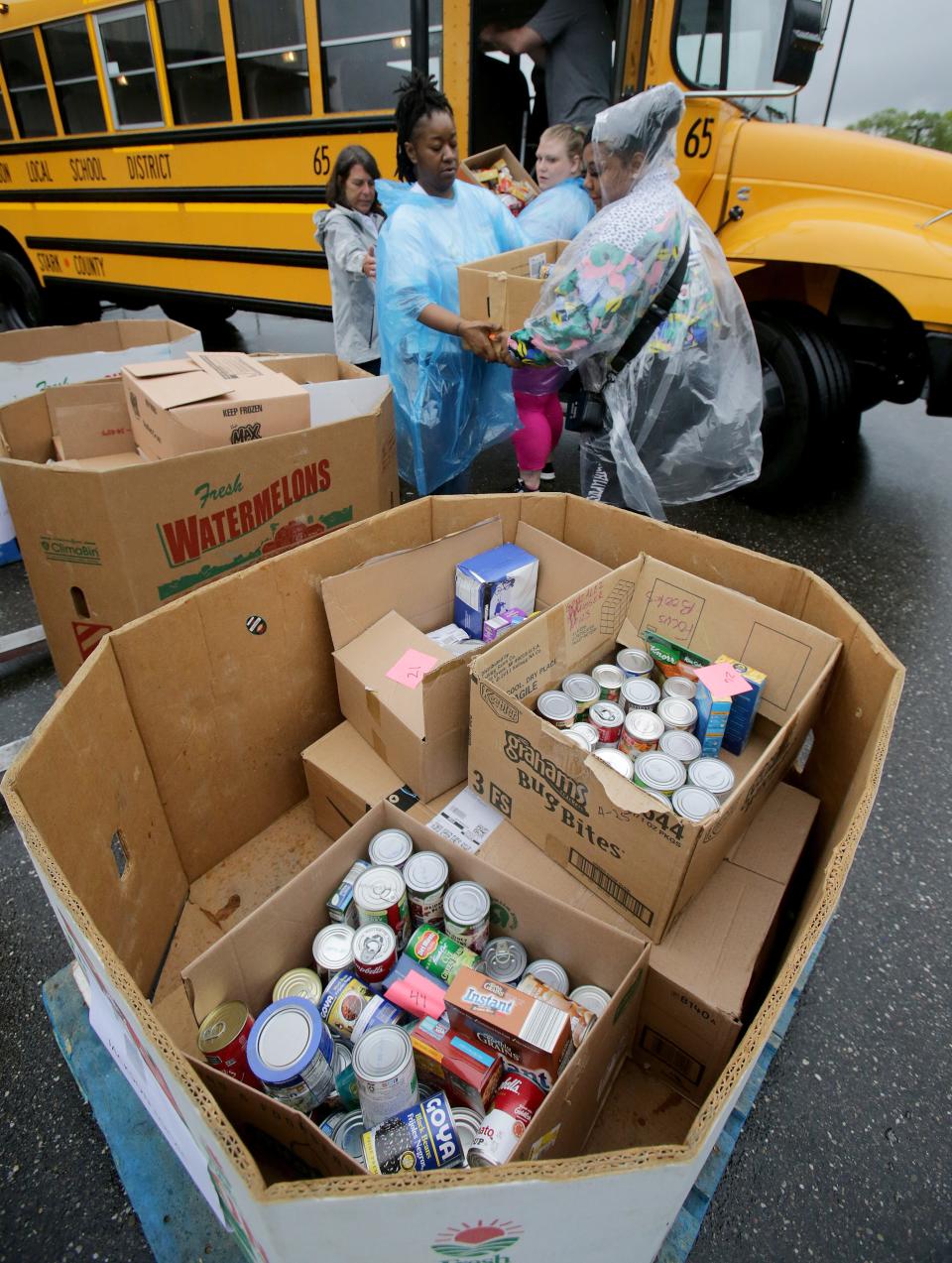 Volunteers, from left, Nancy Licata, Davetta Shy, Mary Nuss and Doneshia Bridges unload food Monday from a Jackson Local school bus at the Akron-Canton Regional Foodbank's Stark Campus in Canton.