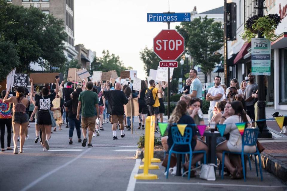 Attendees of a Black Lives Matter block party protest march past restaurant patrons on Front St. in downtown Wilmington, N.C. on Thursday evening, June 25, 2020. The demonstrations, hosted by a group called “the lowercase leaders” and other volunteers, have brought crowds out every day since May 31, when tear gas was deployed on protesters by the New Hanover County Sheriff’s Department during a protest in the wake of George Floyd’s death.