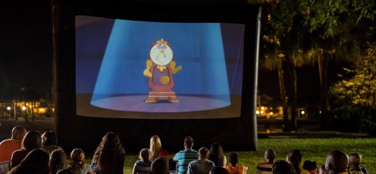 a group of people sitting in front of a large screen