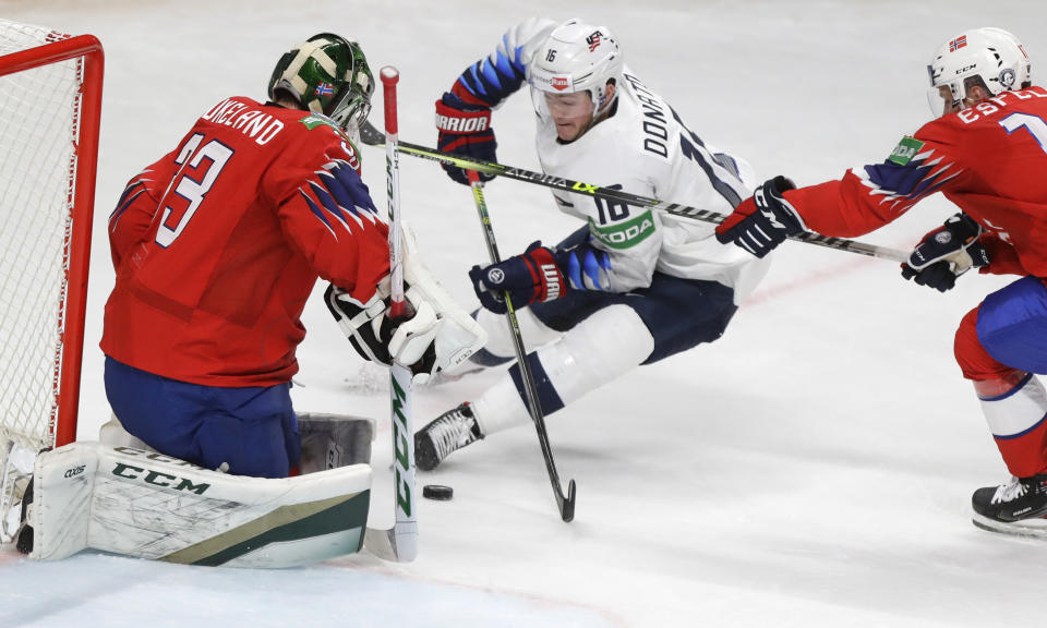 Ryan Donato of the US, centre, challenges for the puck with Norway's goaltender Henrik Haukeland, left, and Norway's Stefan Espeland during the Ice Hockey World Championship group B match between Norway and United States at the Arena in Riga, Latvia, Saturday, May 29, 2021. (AP Photo/Sergei Grits)