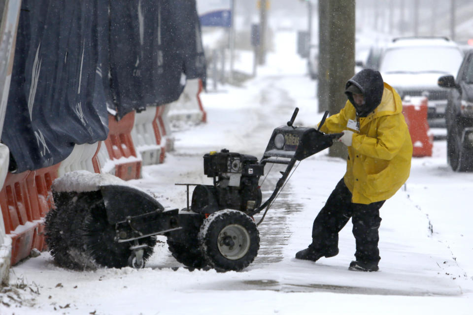 A man works to turn his snow-clearing machine Sunday Jan. 31, 2021 in Philadelphia. After days of frigid temperatures, the Northeast is bracing for a whopper of a storm that could dump well over a foot of snow in many areas and create blizzard-like conditions. (AP Photo/Jacqueline Larma)