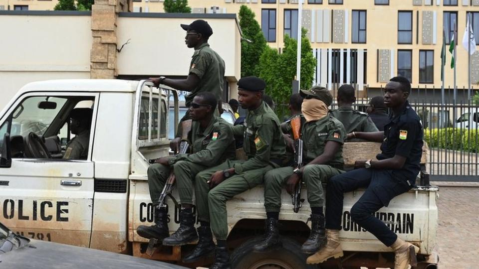A police officer ride on the back of a pick-up truck as they patrol in Niamey on 21 August, 2023.