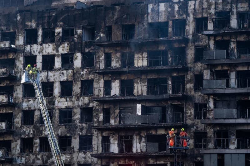 Firefighters work on the fire in the Campanar neighborhood. A large fire 22 February swept through a 14-story building in the Valencia neighborhood of Campanar. At the moment, there are four people dead and 19 missing people that the firefighters are still looking for. Jorge Gil/EUROPA PRESS/dpa