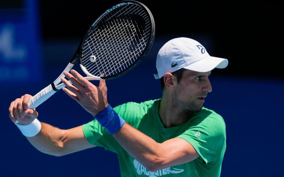 Djokovic on court in Melbourne on Thursday while he awaits the decision on his visa - AP