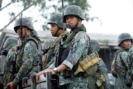 Philippine soldiers ride on a military vehicle while government forces continue their assault against insurgents from the Maute group, in Marawi, Philippines June 26, 2017. REUTERS/Jorge Silva