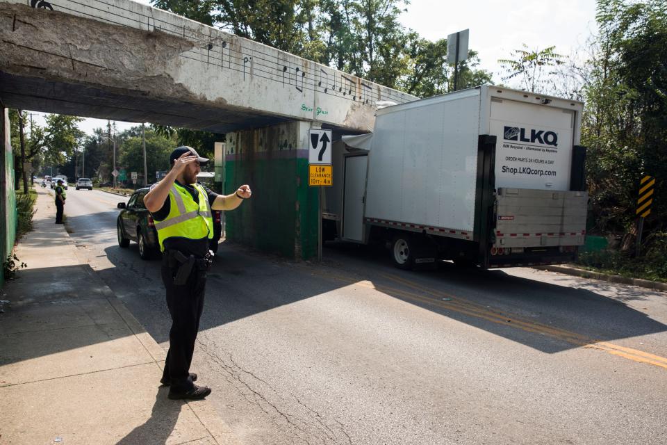 Police direct traffic around a box truck that collided with the railroad bridge over Adams Street in 2018.