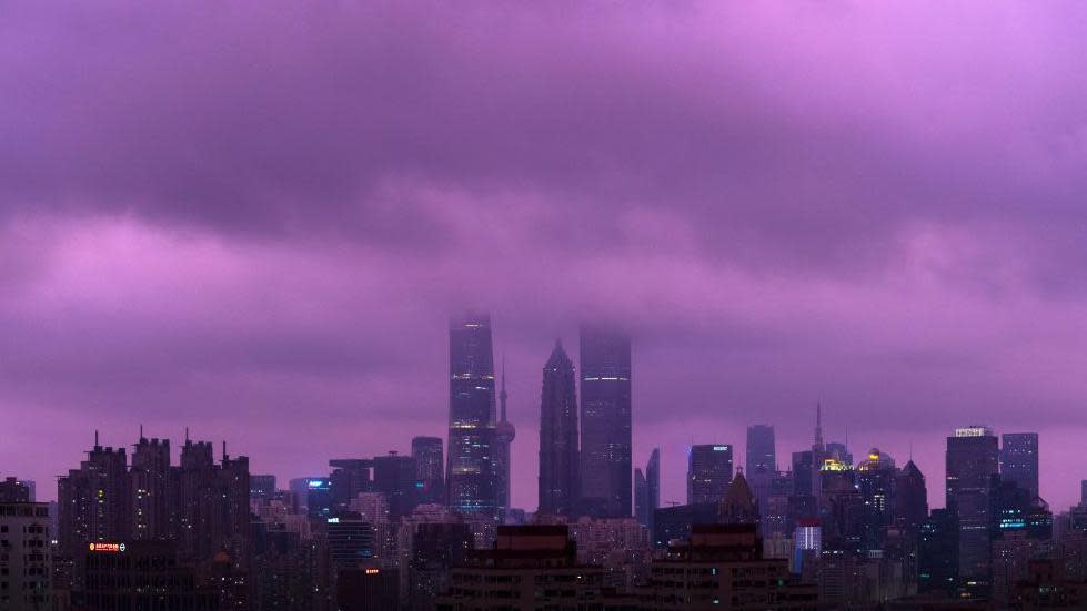 A cityscape of Shanghai's skyscrapers, with the sky and clouds above looking a very rare shade of purple