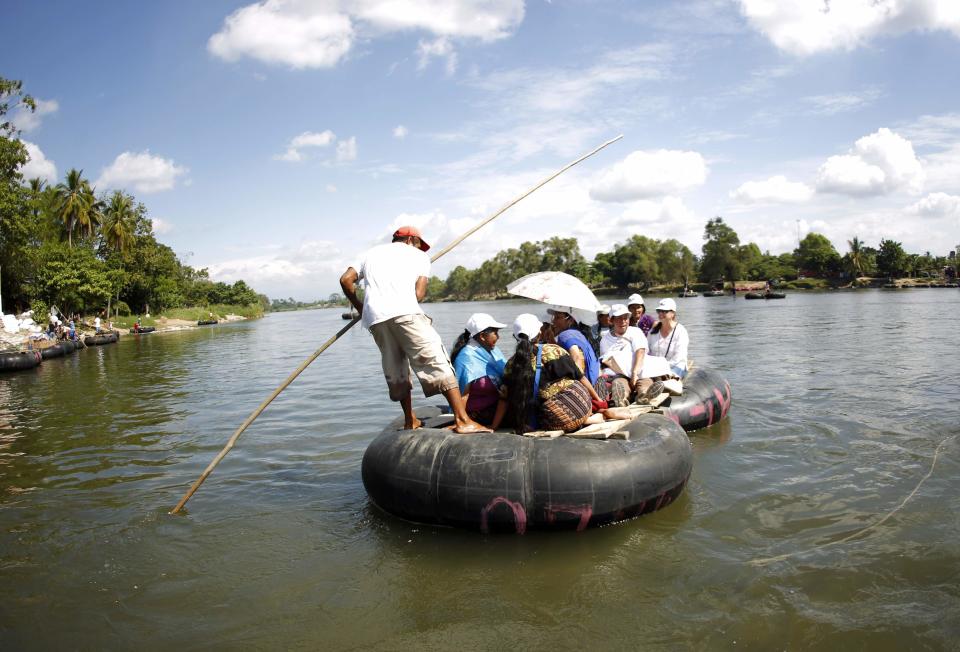 Women from "Caravana de Madres Centroamericanas" (Caravan of Central American Mothers) ride a raft to cross to Guatemala from the Suchiate river in the border of Ciudad Hidalgo, Chiapas, south of Mexico, December 18, 2013. According to the organizers, the group which is made up of relatives of people who went missing while making their way to the U.S. went to Mexico in the last two weeks to demand that the governments of Mexico and Central America stop the kidnappings and crimes committed by organised criminal groups against migrants. REUTERS/Jorge Dan Lopez (MEXICO - Tags: CRIME LAW SOCIETY IMMIGRATION POLITICS)
