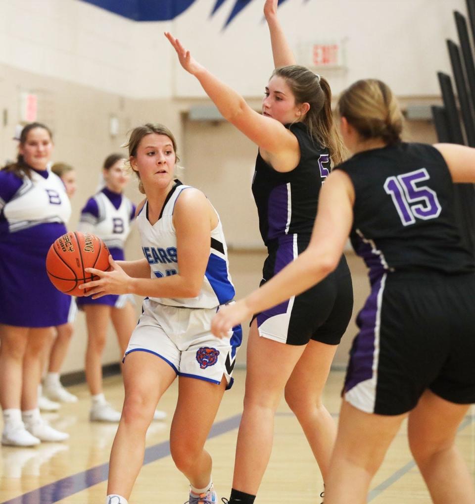 Danville’s Kenna Furnald looks to pass the ball out of the lane while guarded by Burlington’s Lily Bartels.