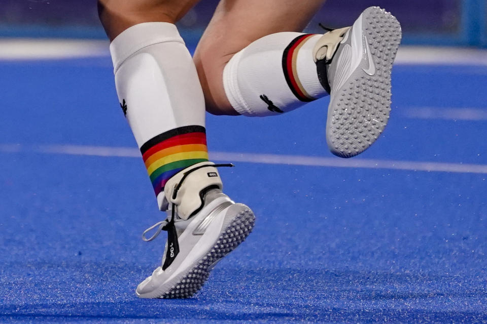 Germany's Nike Lorenz wears a rainbow emblazoned shin guard as she passes the ball during a women's field hockey match against India at the 2020 Summer Olympics, Monday, July 26, 2021, in Tokyo, Japan. (AP Photo/John Minchillo)